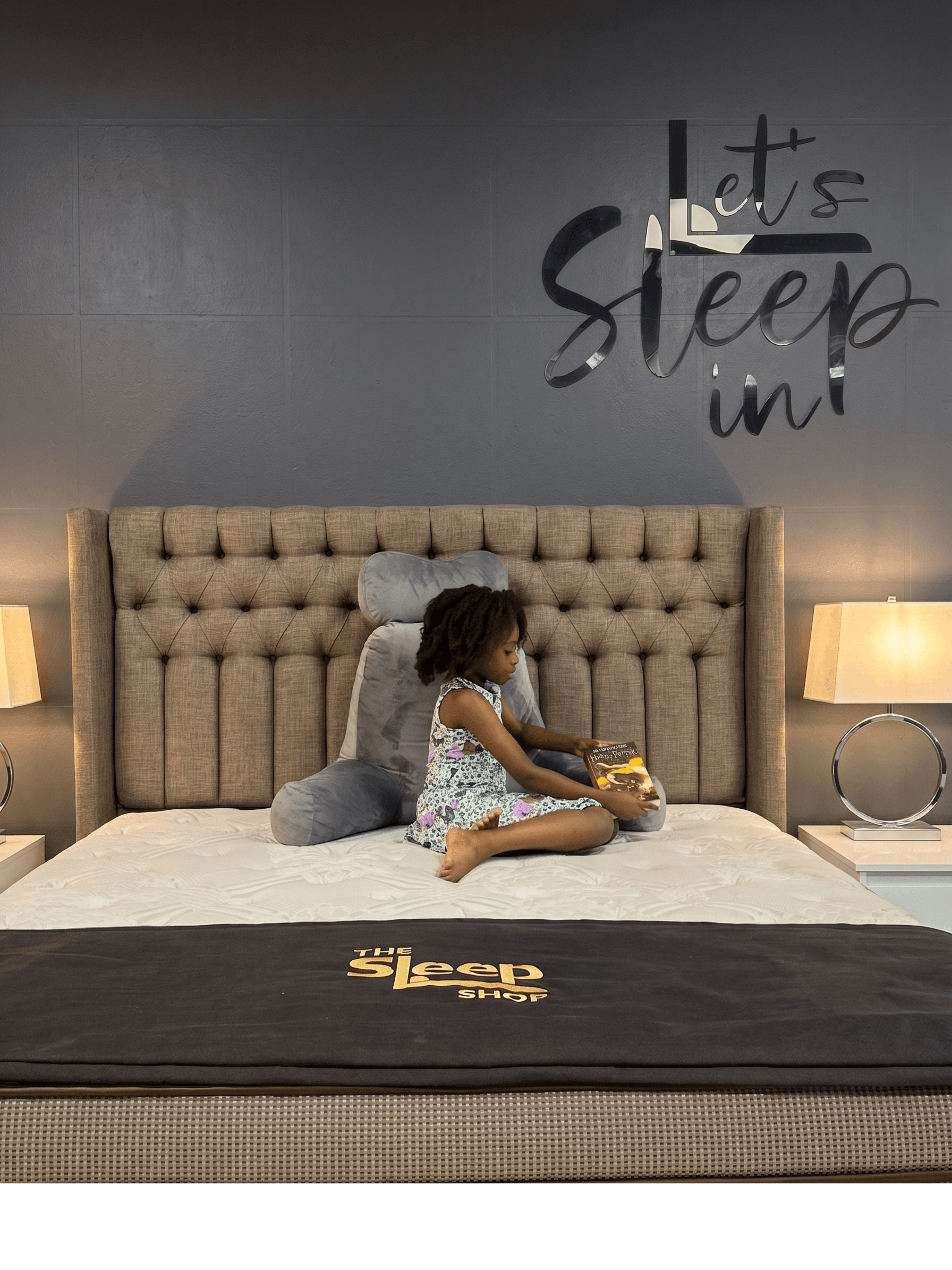 A child resting on a bed in The Sleep Shop showroom